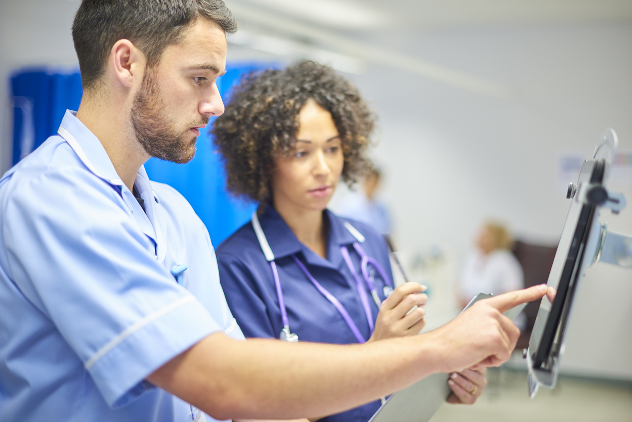 A nurse informatics specialist inputs data on a tablet.