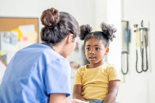 A family nurse practitioner examines a young patient in a medical office.