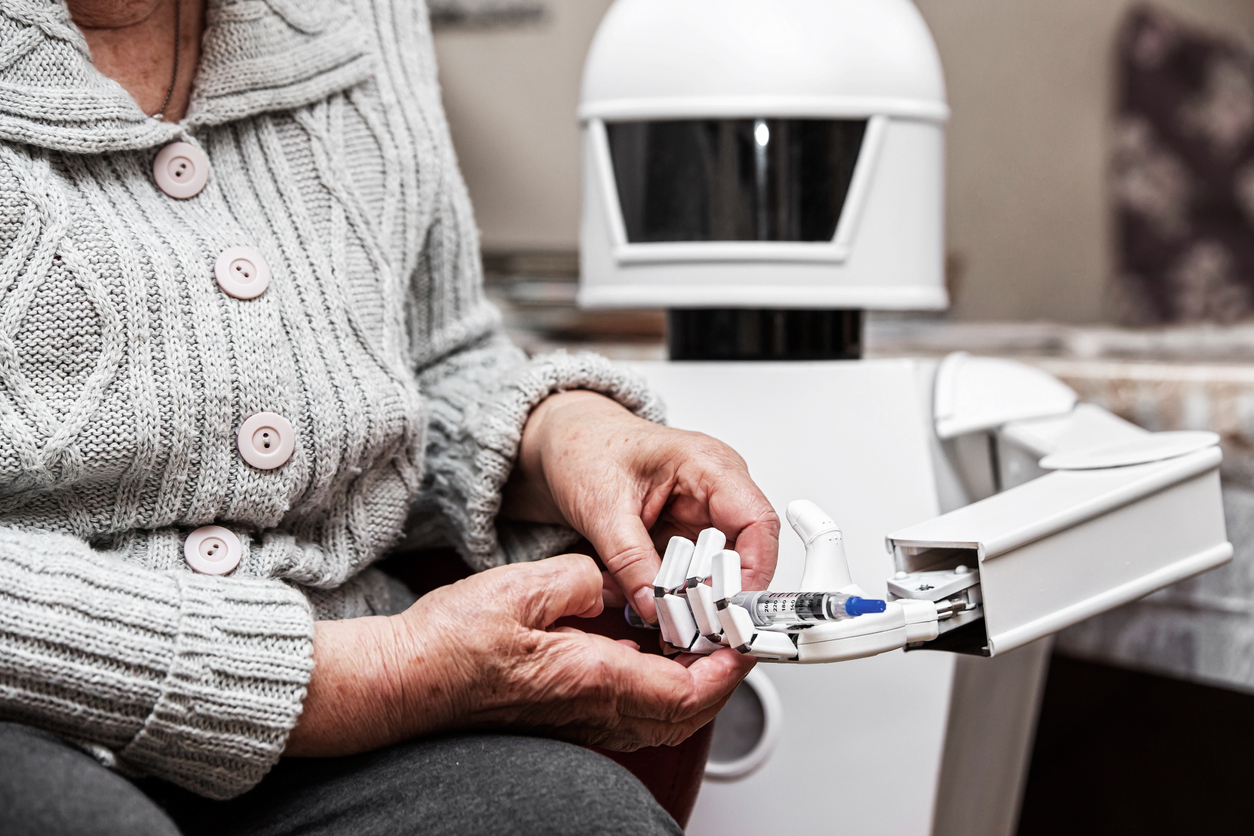 A robot gives a pen to a patient.