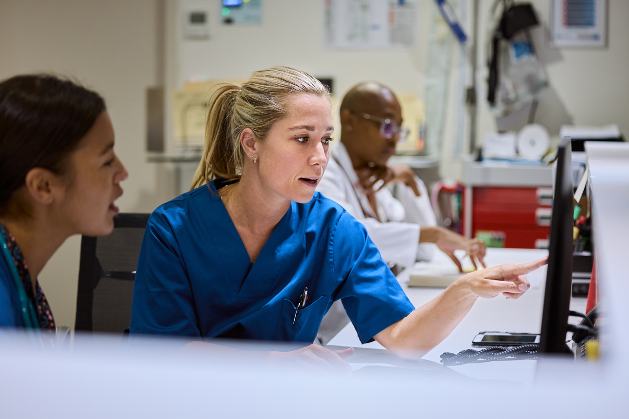Nurses review digital health documentation on a computer.