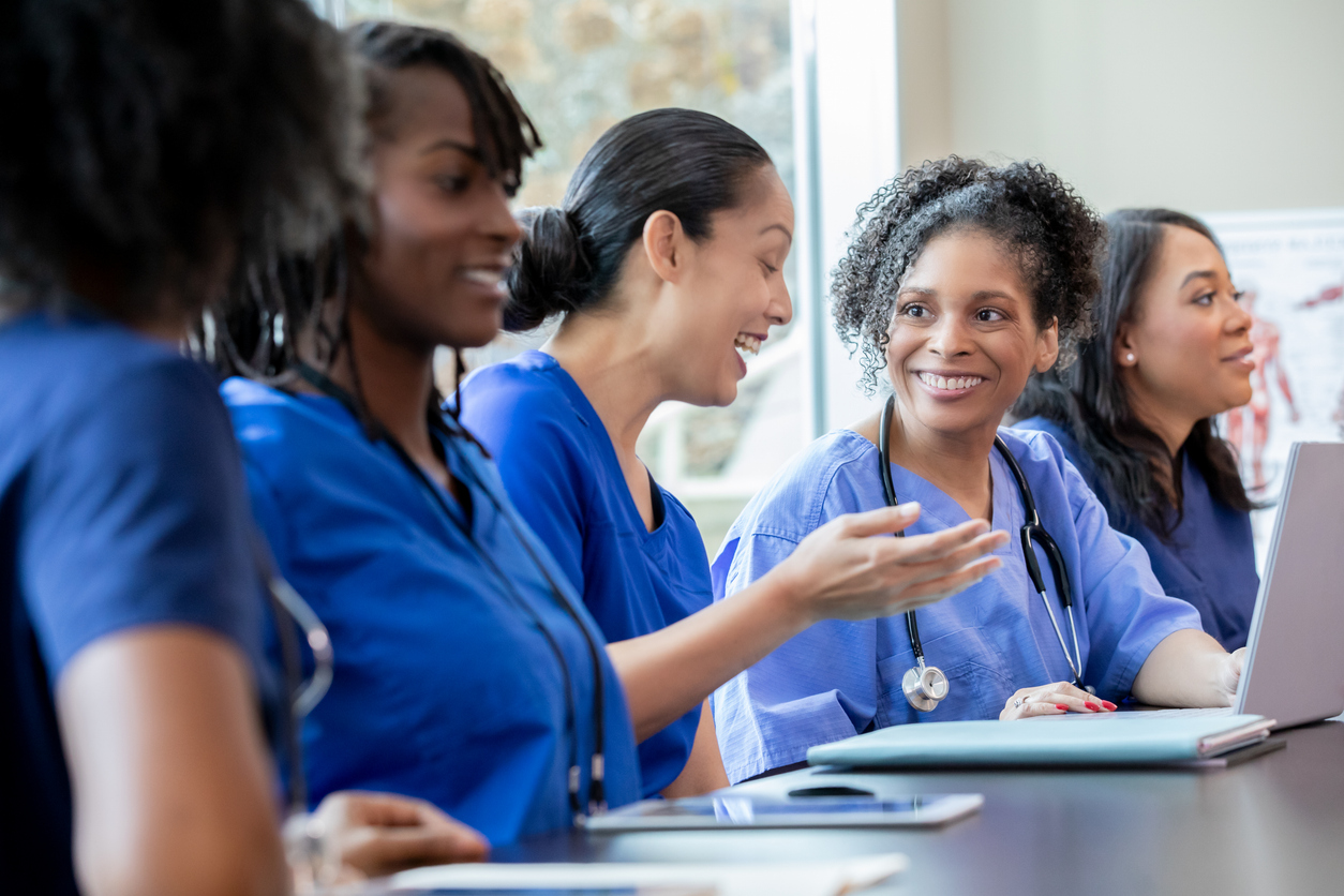  Nurses meet around a conference table.